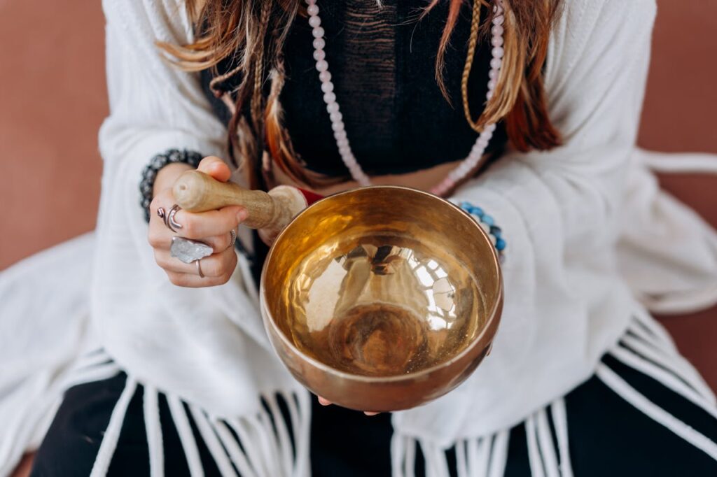 A woman holding a singing bowl, engaging in a peaceful meditation practice.